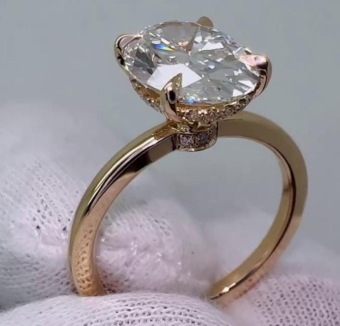 Oval solitaire engagement ring featuring a hidden diamond halo
