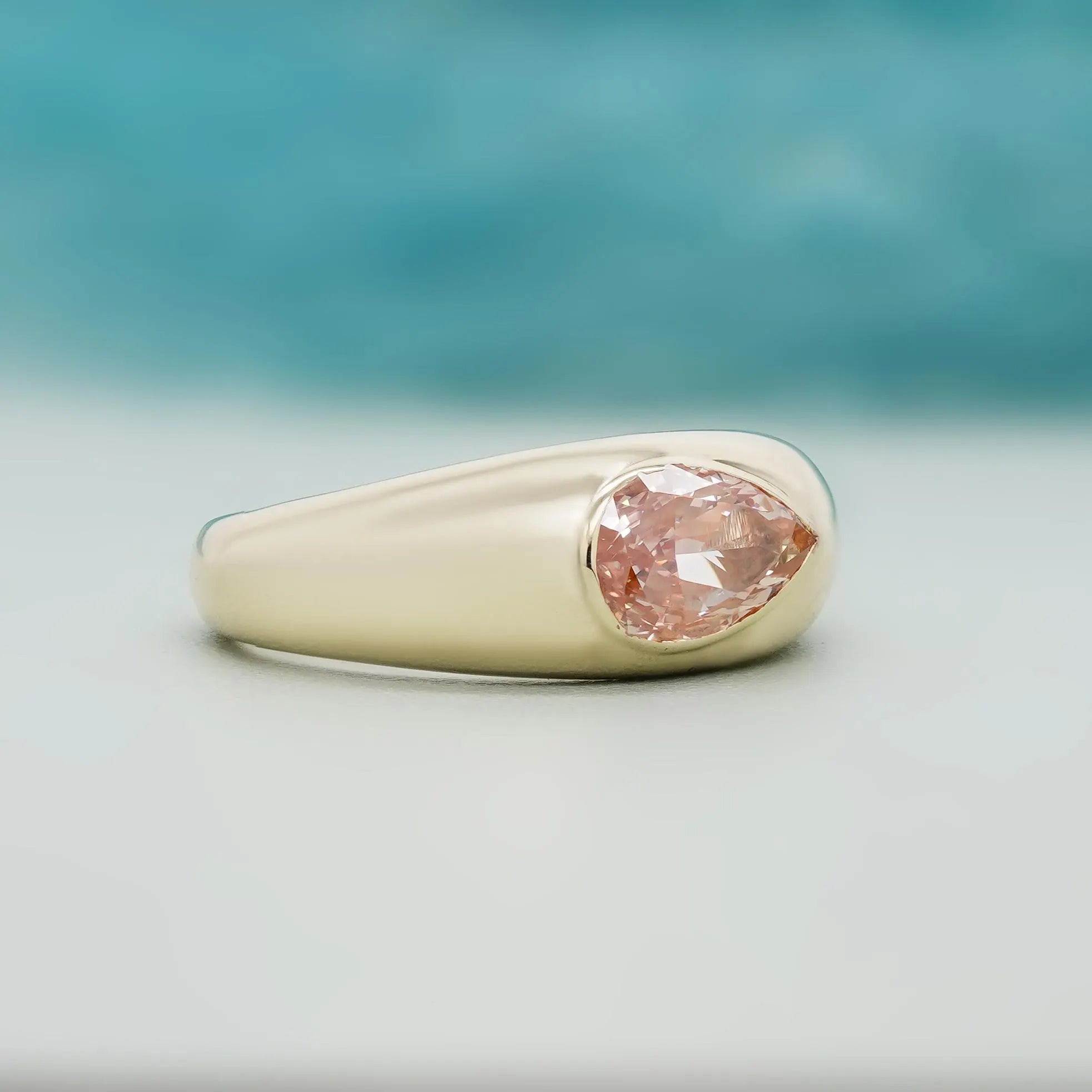 Pear cut pink lab grown diamond ring with yellow gold bezel setting