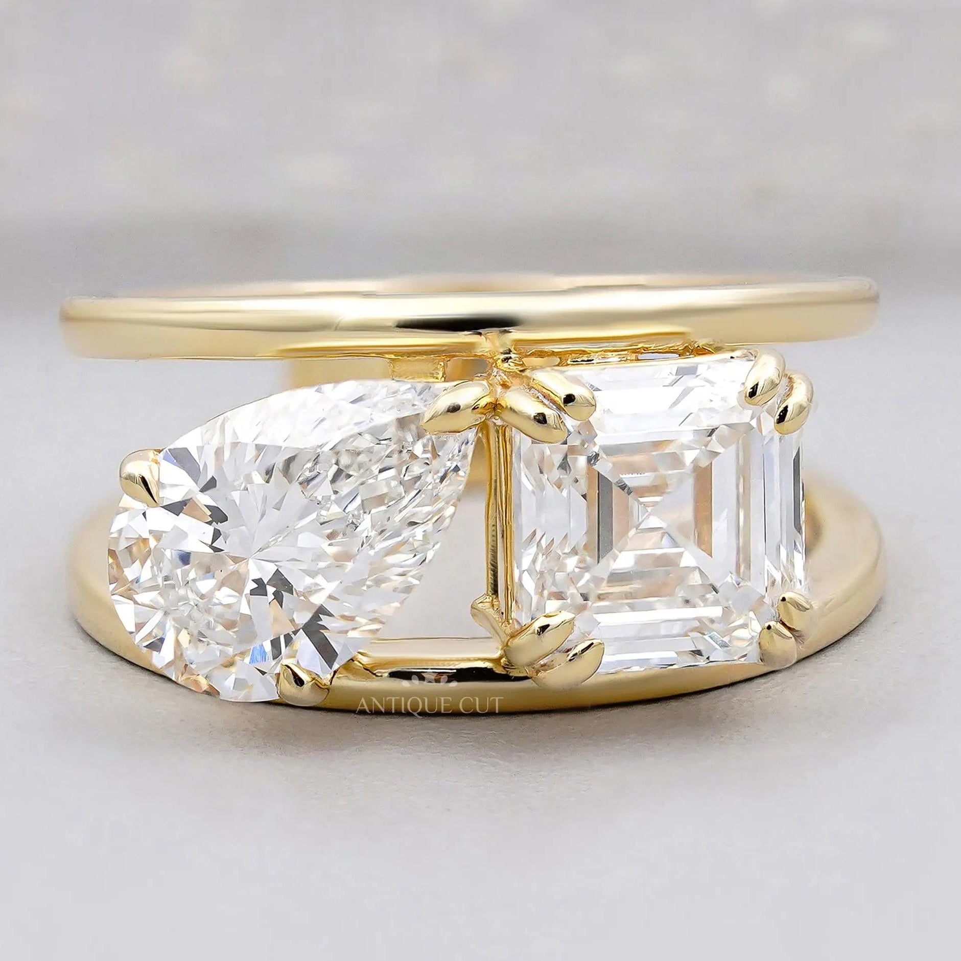 Emerald and pear two stone engagement ring in yellow gold