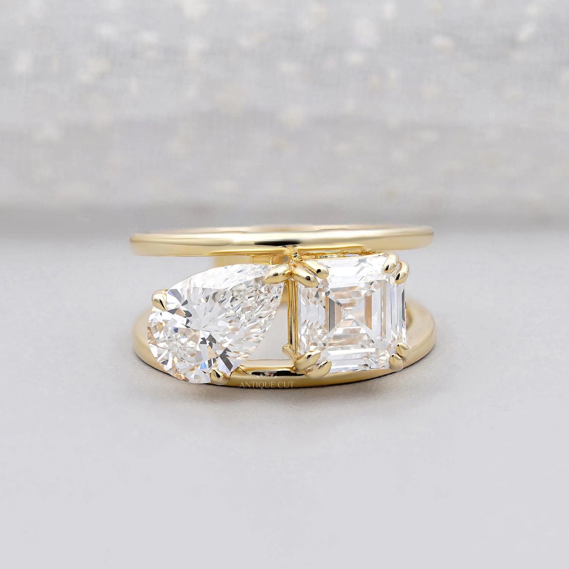 Emerald and pear two stone engagement ring in yellow gold