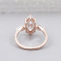 Rose gold ring with a pear-shaped diamond on a light gray background

