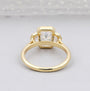 Gold ring with three diamonds on a light gray background

