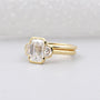 Gold ring with a diamond on a light gray background

