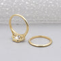 Gold ring with a diamond on a light gray background

