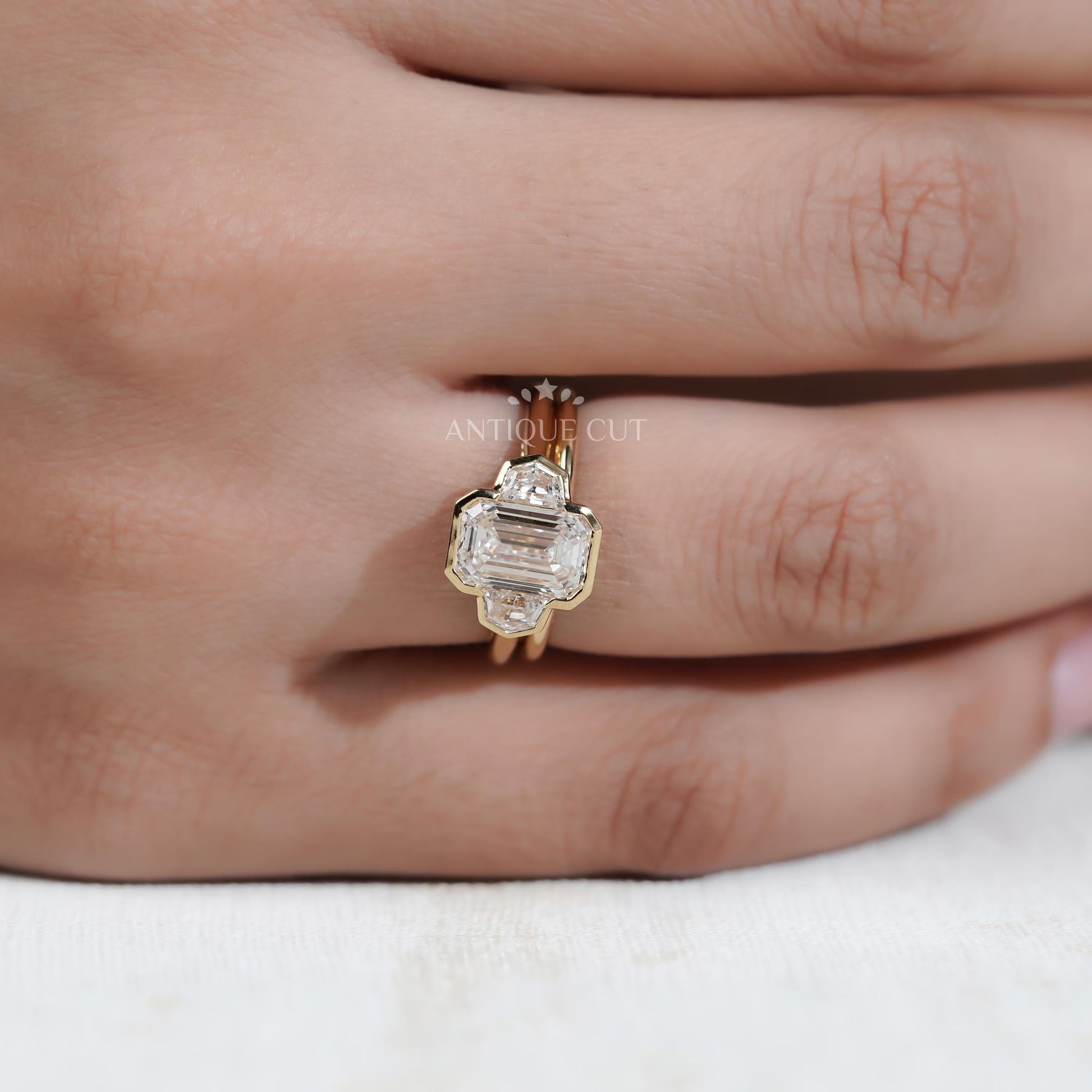 Gold ring with a diamond on a hand, labeled 'Antique Cut'.

