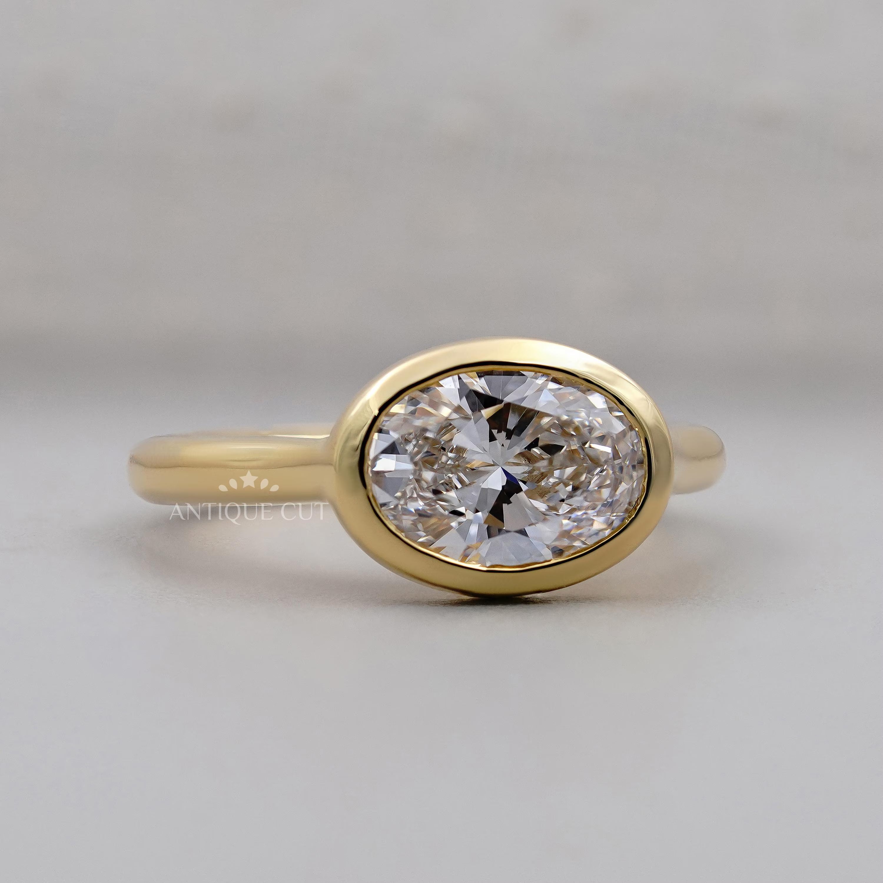 Gold ring with a large diamond on a light gray background

