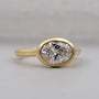 Gold ring with a large diamond on a light gray background

