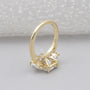 Gold ring with a diamond on a light gray background


