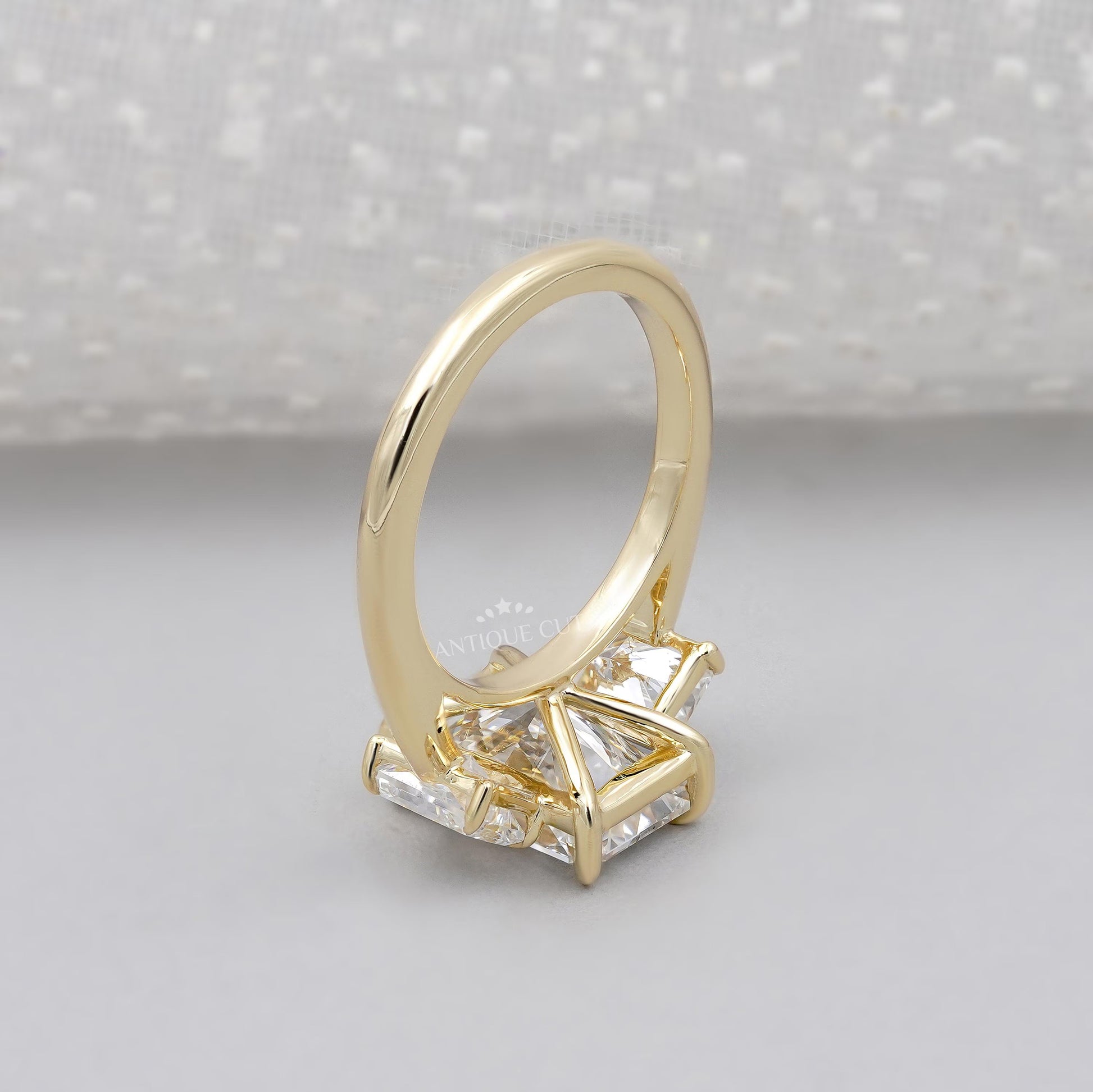 Gold ring with a diamond on a light gray background

