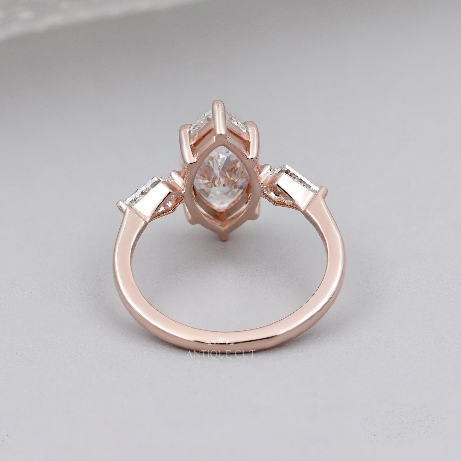 Rose gold ring with a diamond on a light gray background


