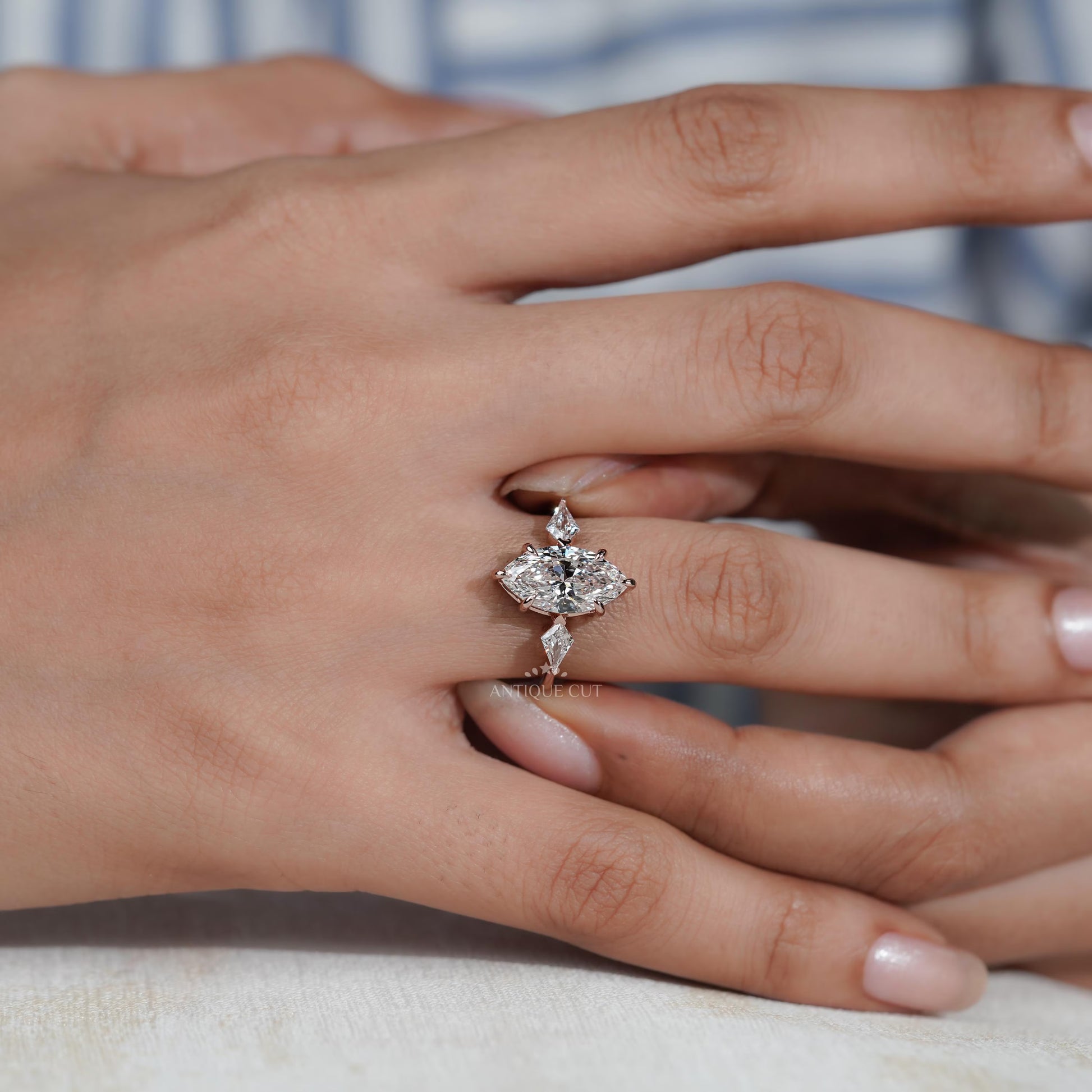 Close-up of a hand wearing a diamond ring with a blurred background

