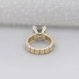 Gold ring with a diamond on a light gray background

