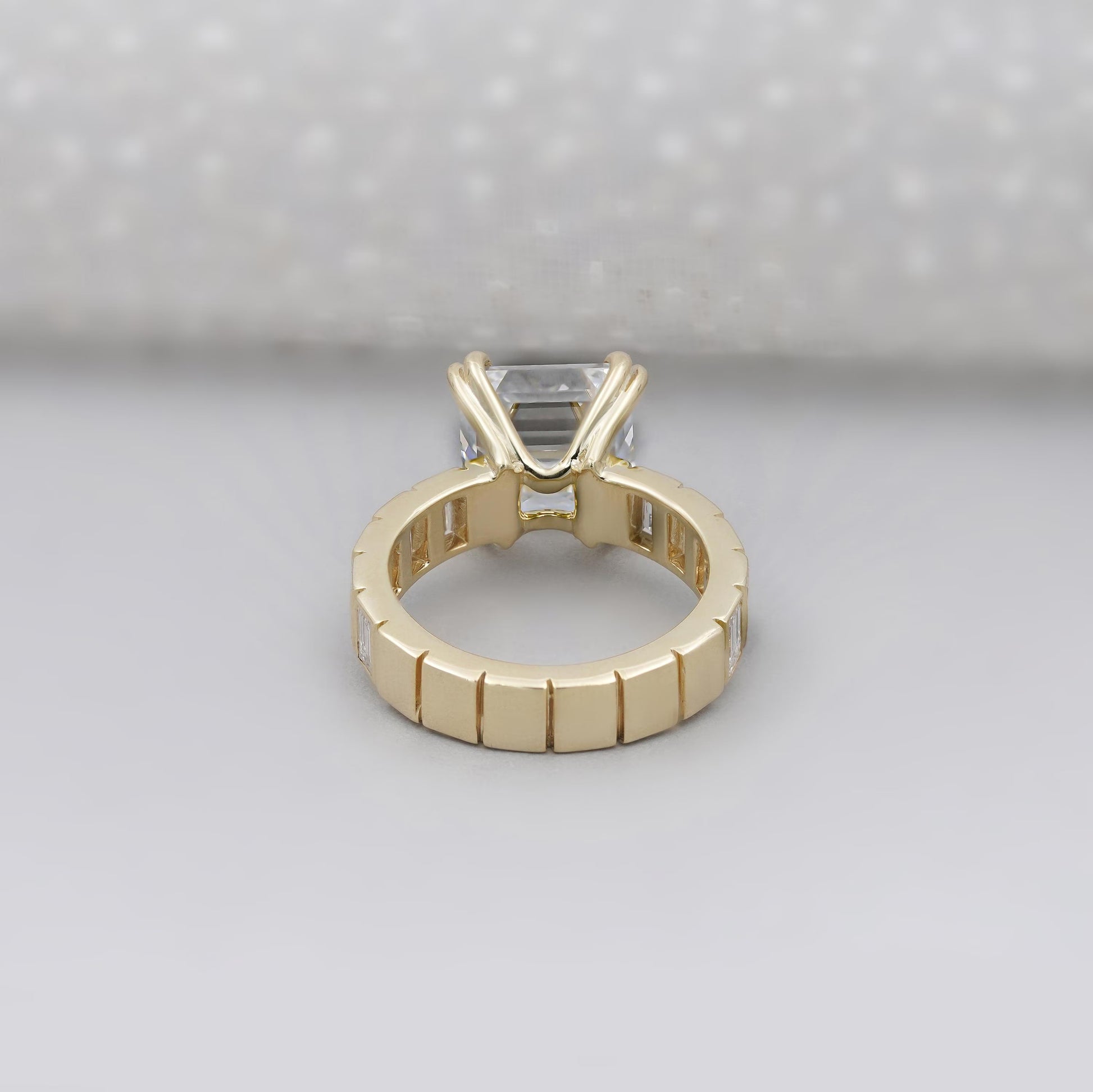Gold ring with a diamond on a light gray background

