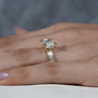 Gold ring with a large diamond on a person's finger against a blurred background

