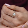 Close-up of a hand wearing a diamond ring with a blurred background