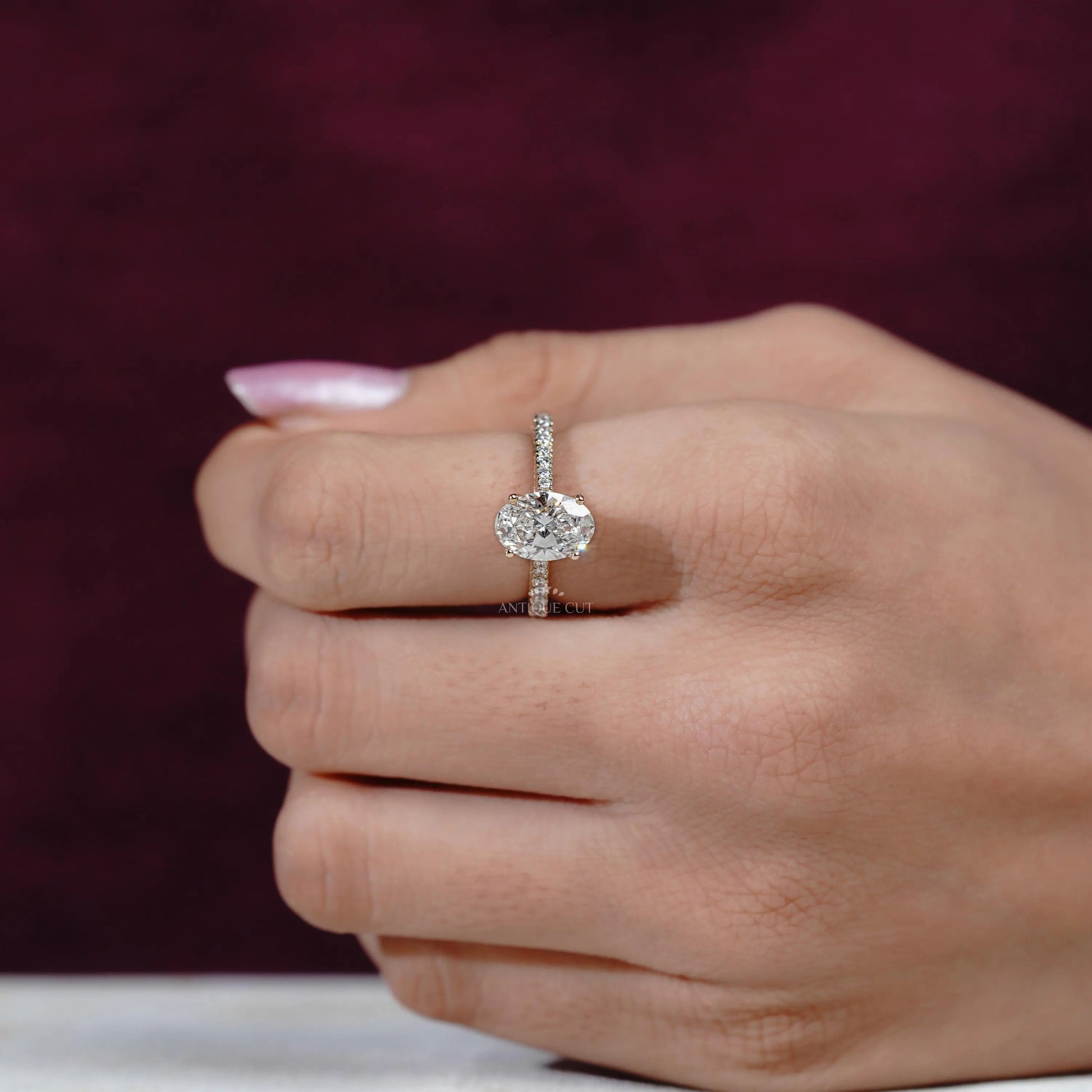 Close-up of a hand wearing a diamond ring with a blurred background

