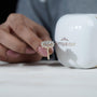 Gold earring with diamonds held by a hand next to a white container labeled Antiquecut'

