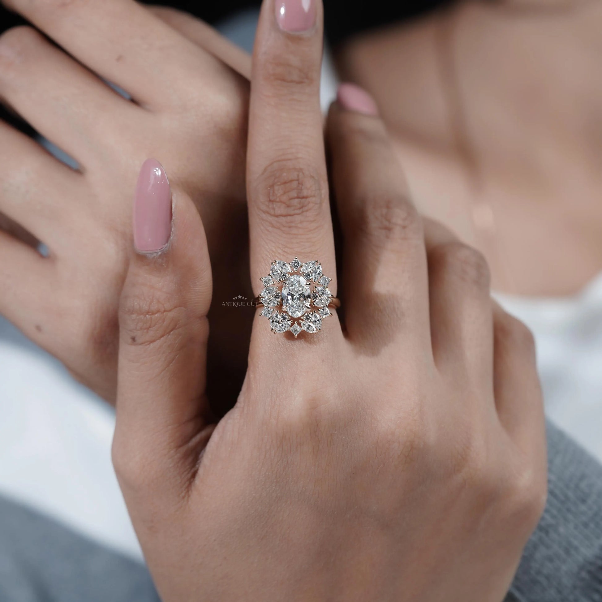 Close-up of a hand wearing a diamond ring with a blurred background