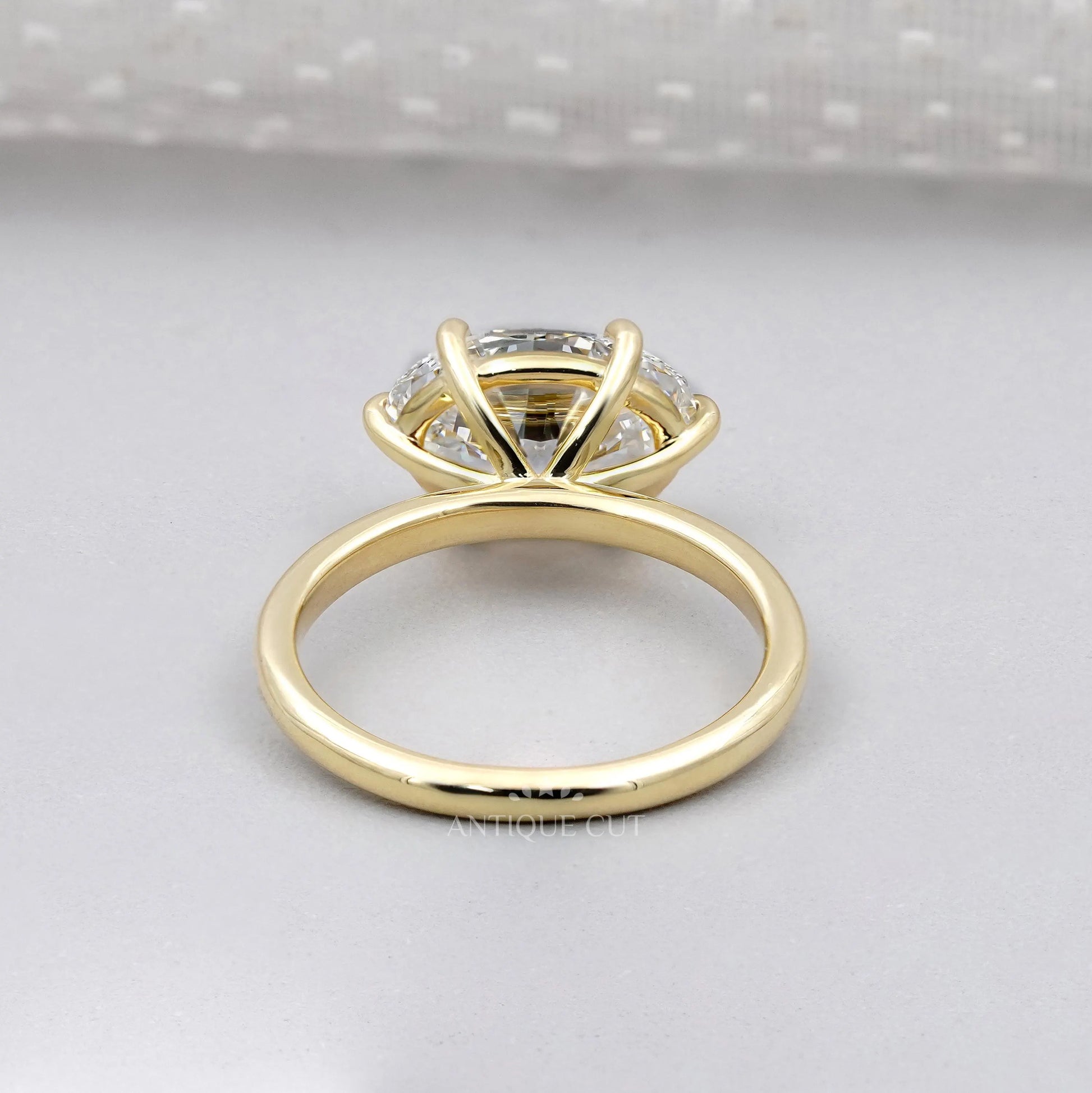 Gold ring with a diamond on a light gray background

