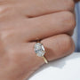 Gold ring with a diamond on a person's finger, brand Antiquecut

