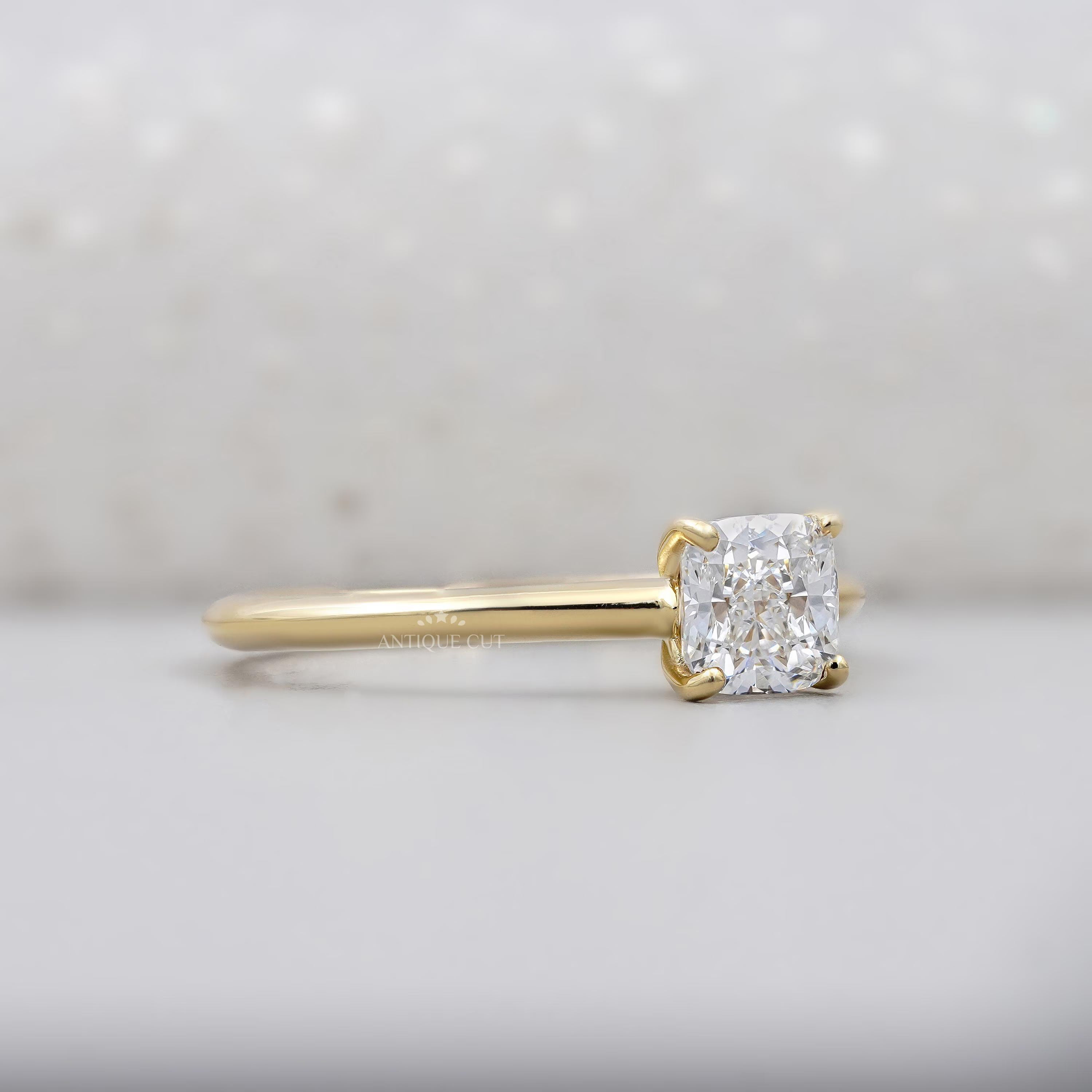 Gold ring with a diamond on a light gray background

