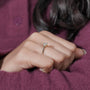 Gold ring with a diamond on a light gray background

