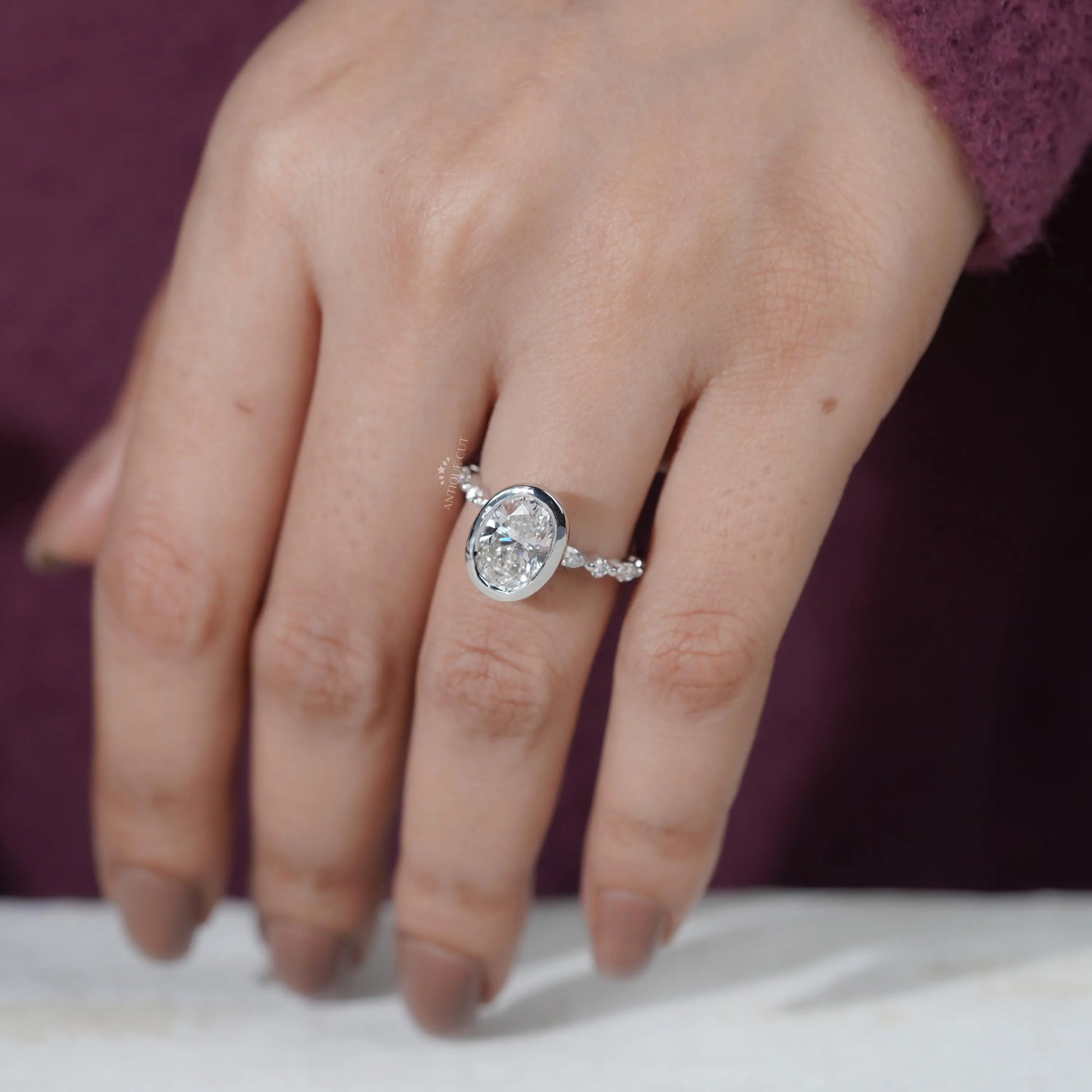Close-up of a hand wearing a diamond ring with a blurred background

