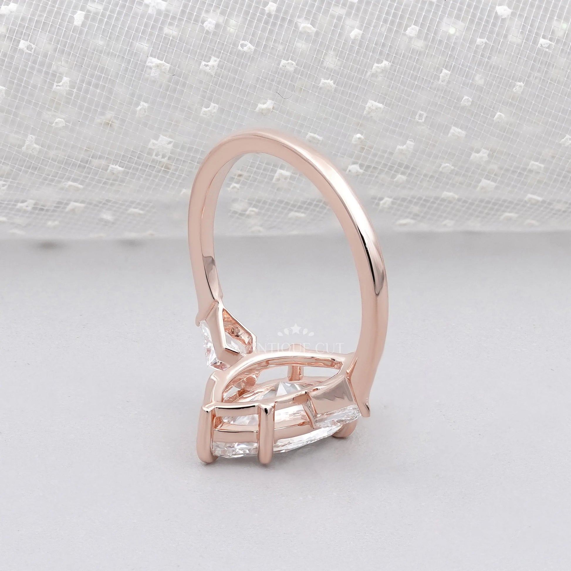 Rose gold ring with a clear gemstone on a white background

