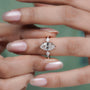 Diamond ring on a finger with a blurred green background

