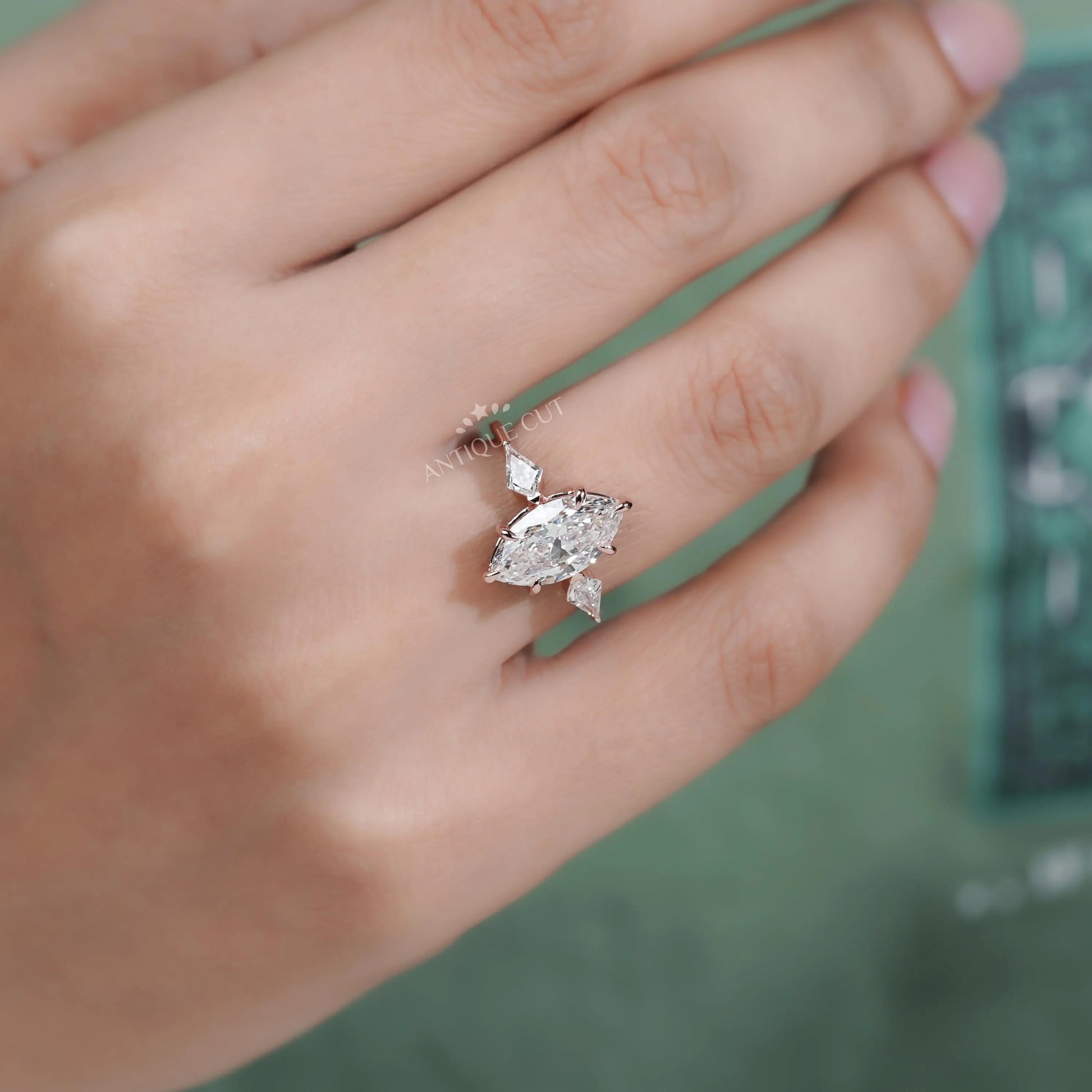 Diamond ring on a hand with a blurred green background

