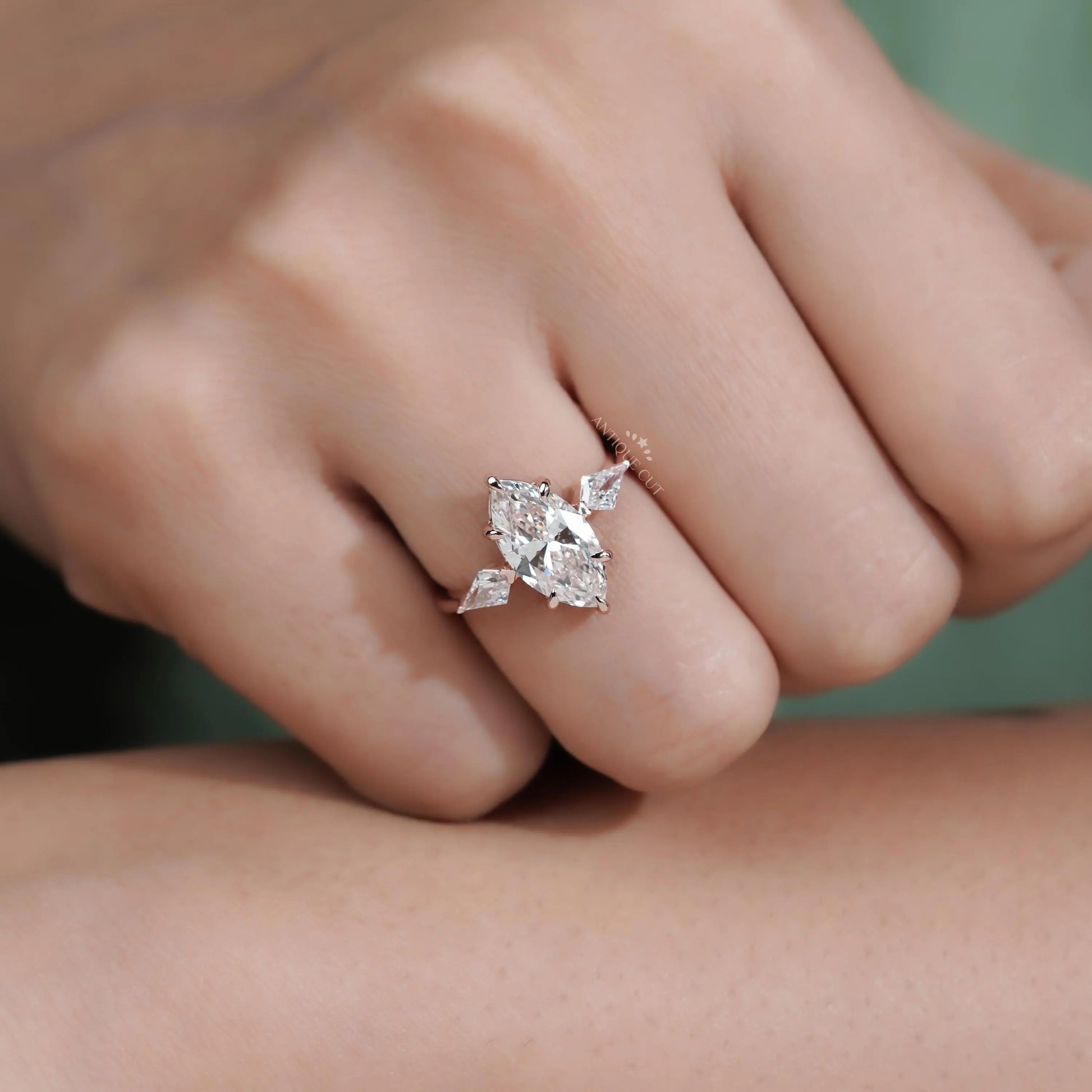 Close-up of a hand wearing a diamond ring on a neutral background

