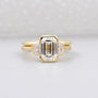 Gold ring with a large central diamond and smaller diamonds on a light gray background

