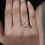 Gold ring with a diamond on a person's finger against a blurred background