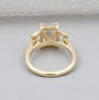 Gold ring with three diamond stones on a gray background

