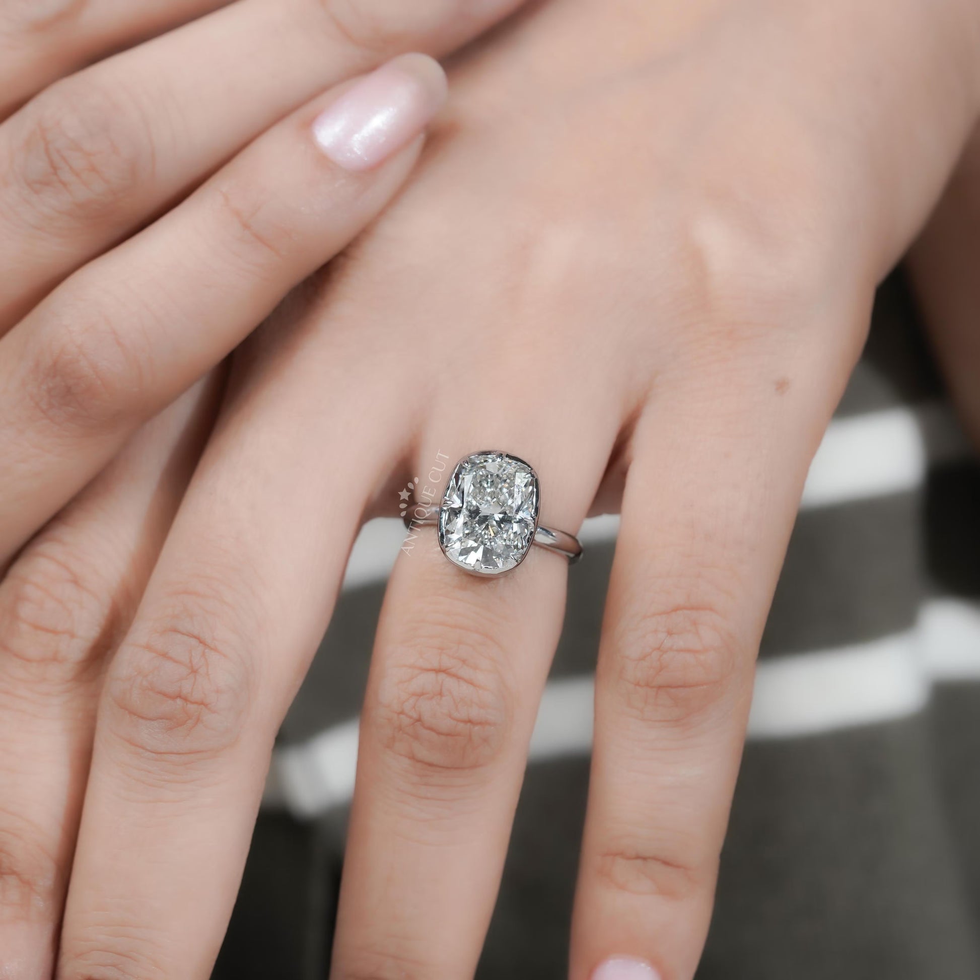 Diamond ring on a finger with a blurred background

