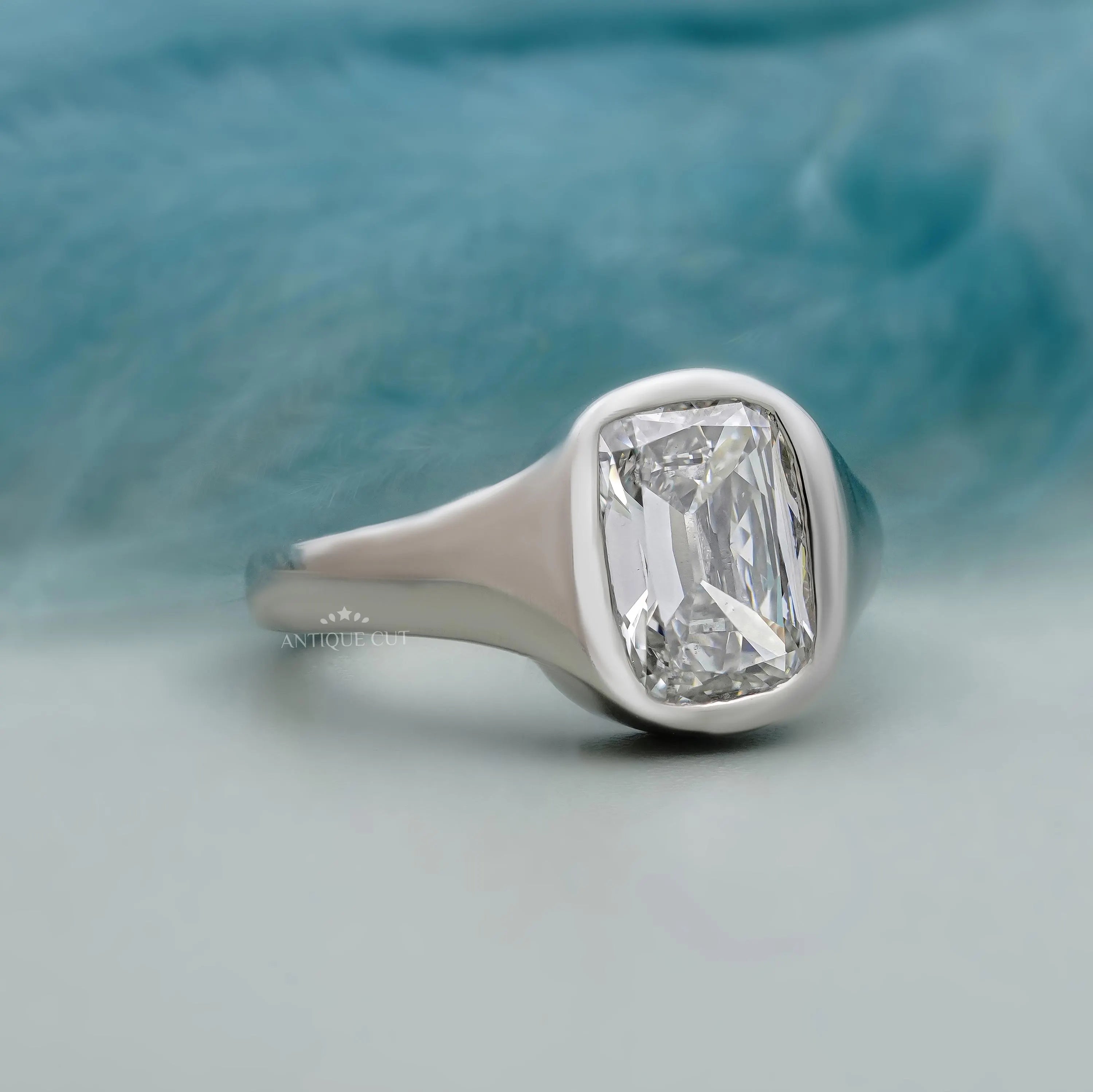 Silver ring with a large diamond on a light blue background