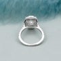 Silver ring with a diamond on a light gray background

