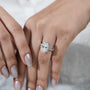 Diamond ring held by a hand with 'AntiqueCut' branding in the background

