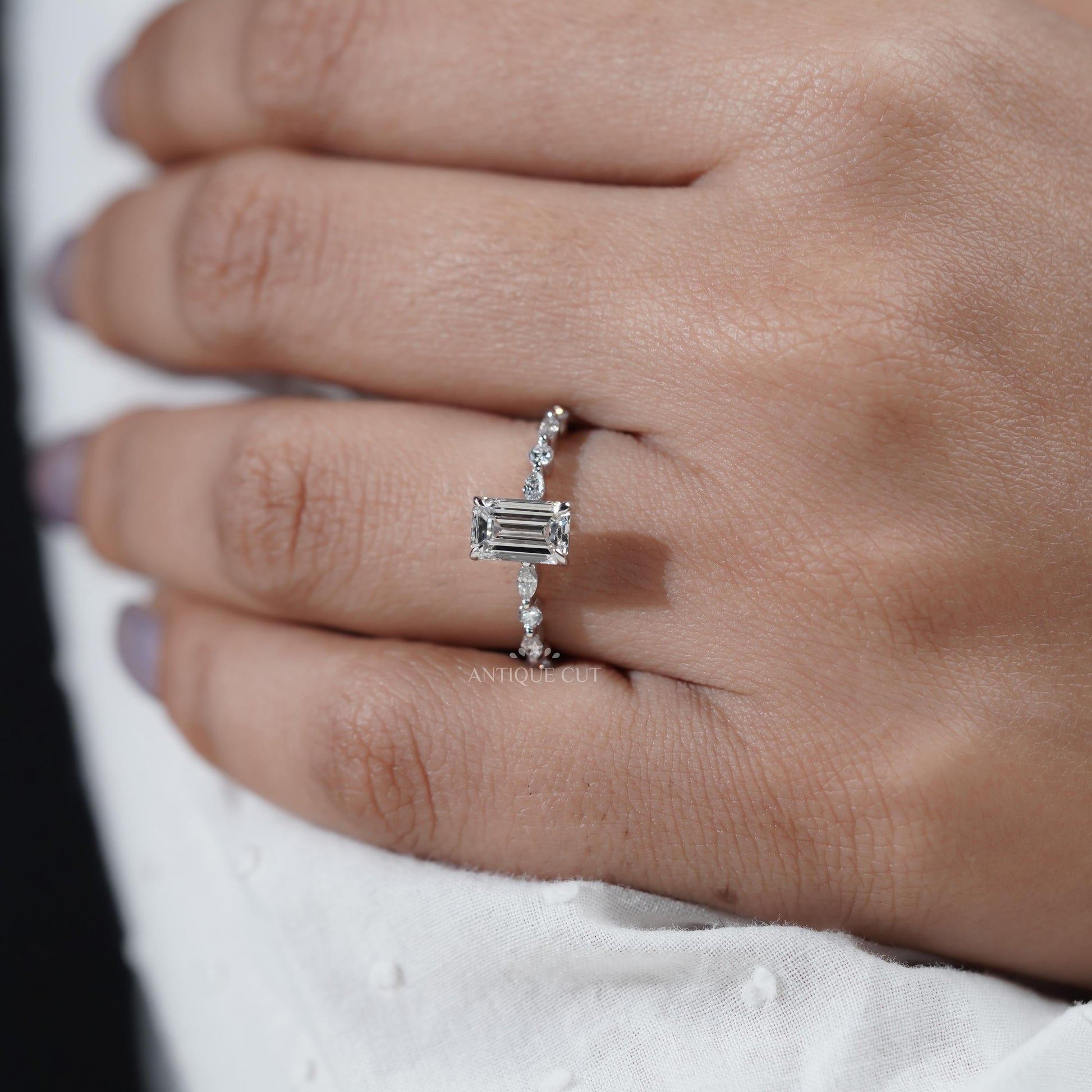 Silver ring with a diamond on a hand with light purple nail polish

