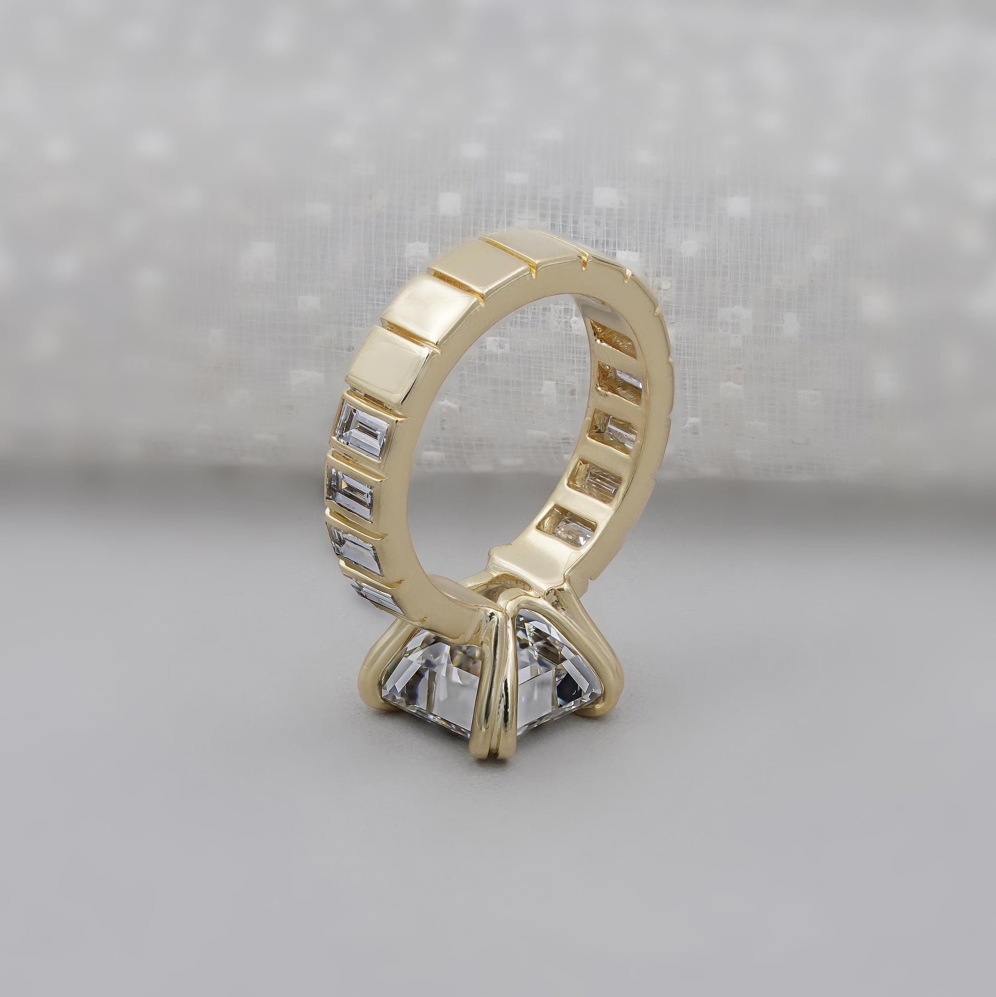 Gold ring with diamond accents on a gray background

