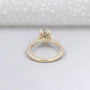 Gold ring with a diamond on a light gray background

