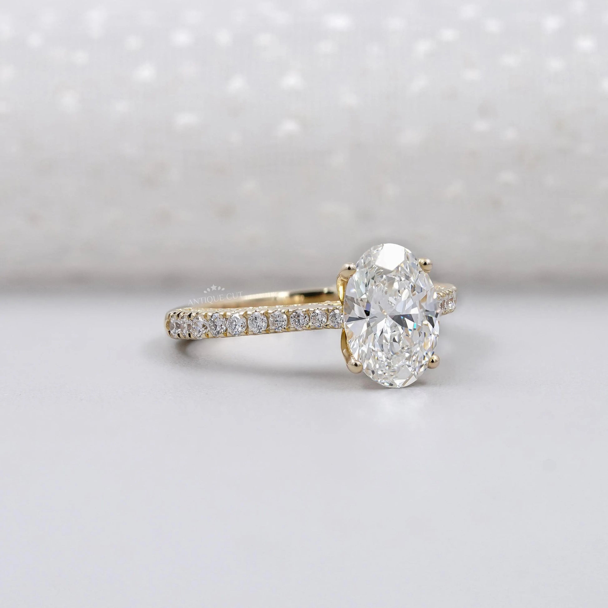 Diamond ring with gold band on a light gray background

