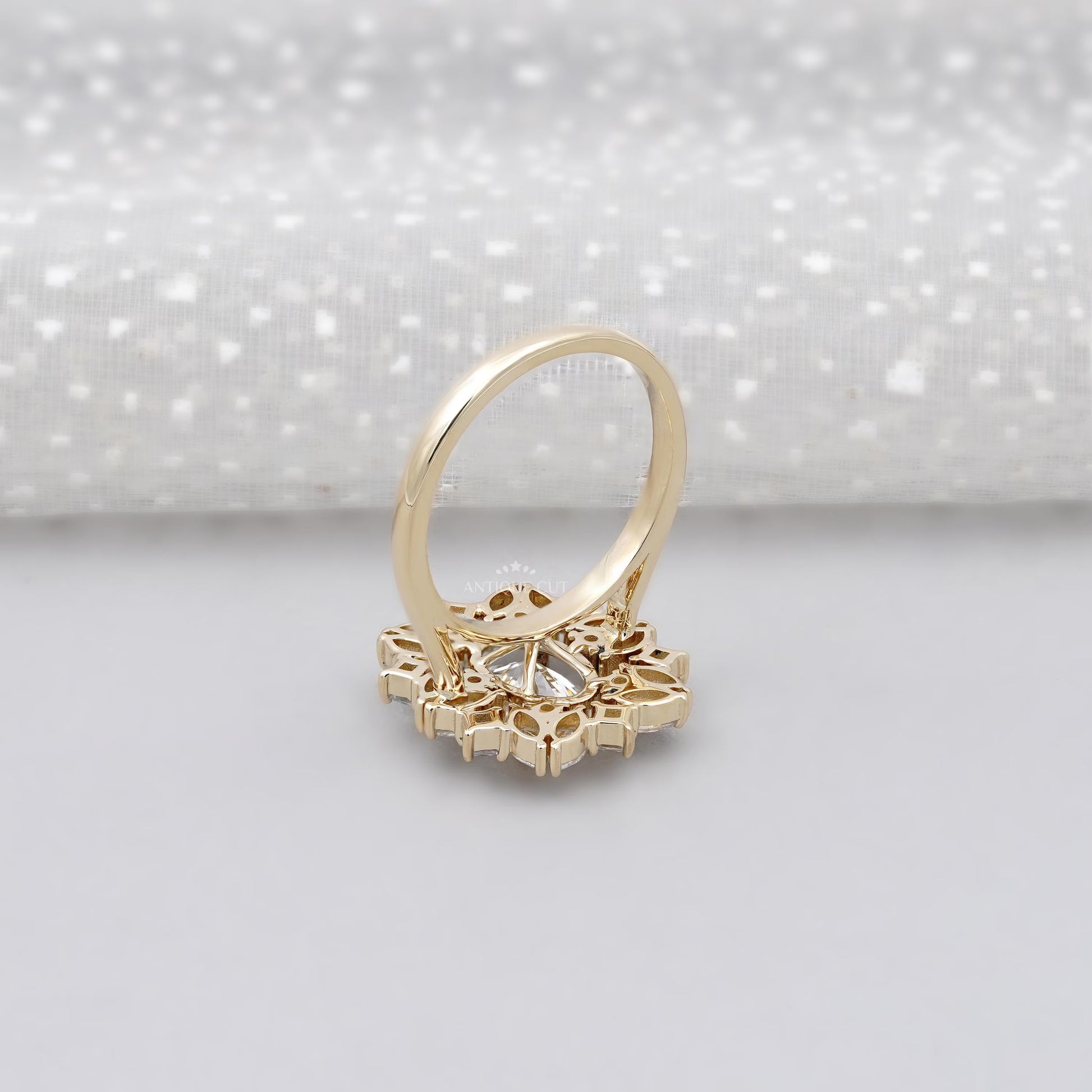 Gold ring with a diamond on a light gray background