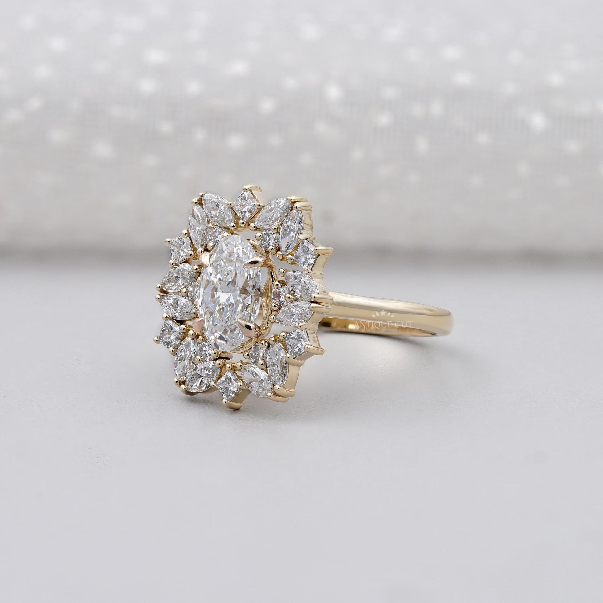 Gold ring with diamond cluster on a light gray background

