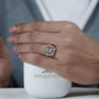 Gold earring with diamonds held by a hand next to a white container labeled AntiqueCut

