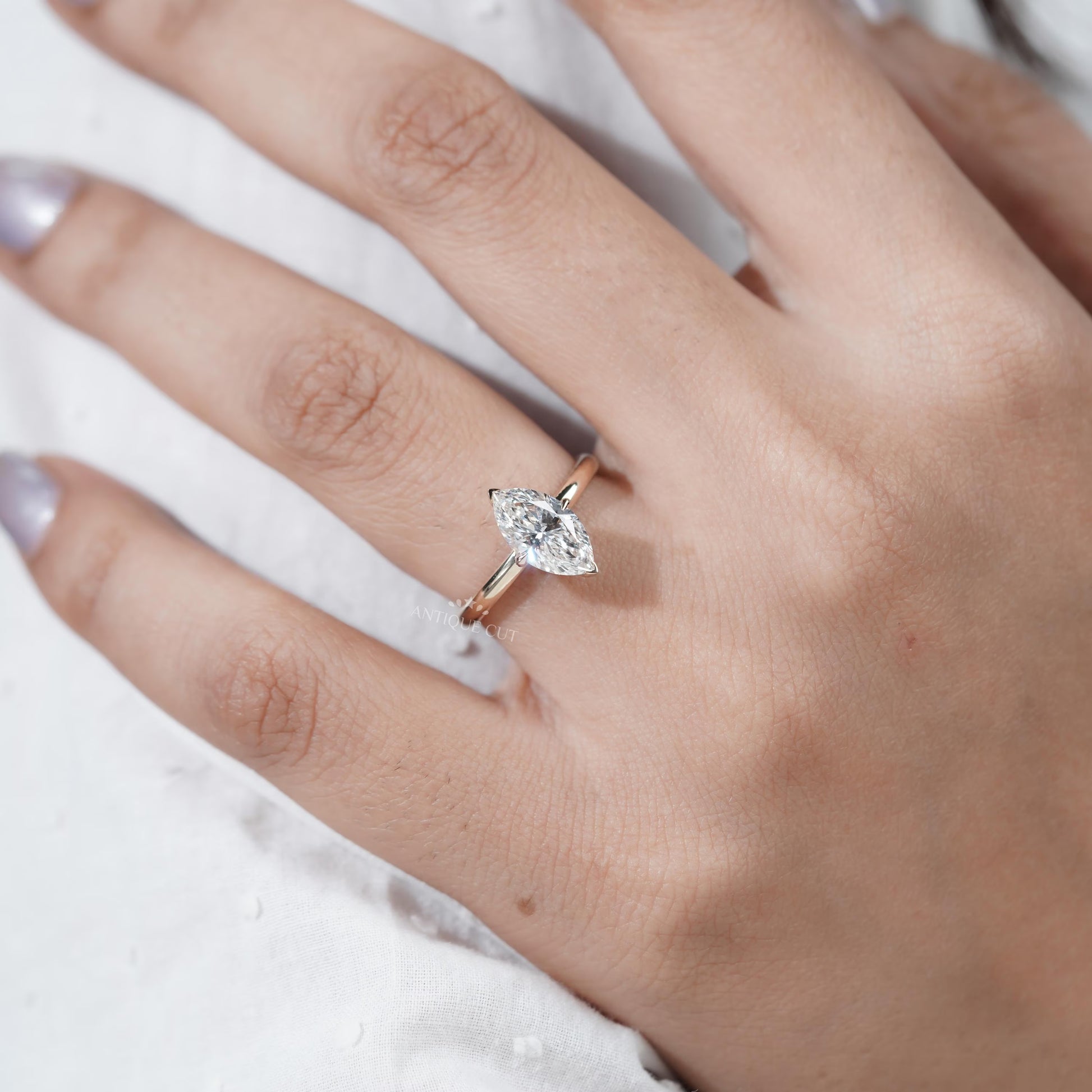 Close-up of a hand wearing a diamond ring on a white background

