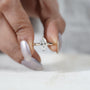 Close-up of a hand wearing a diamond ring on a white background

