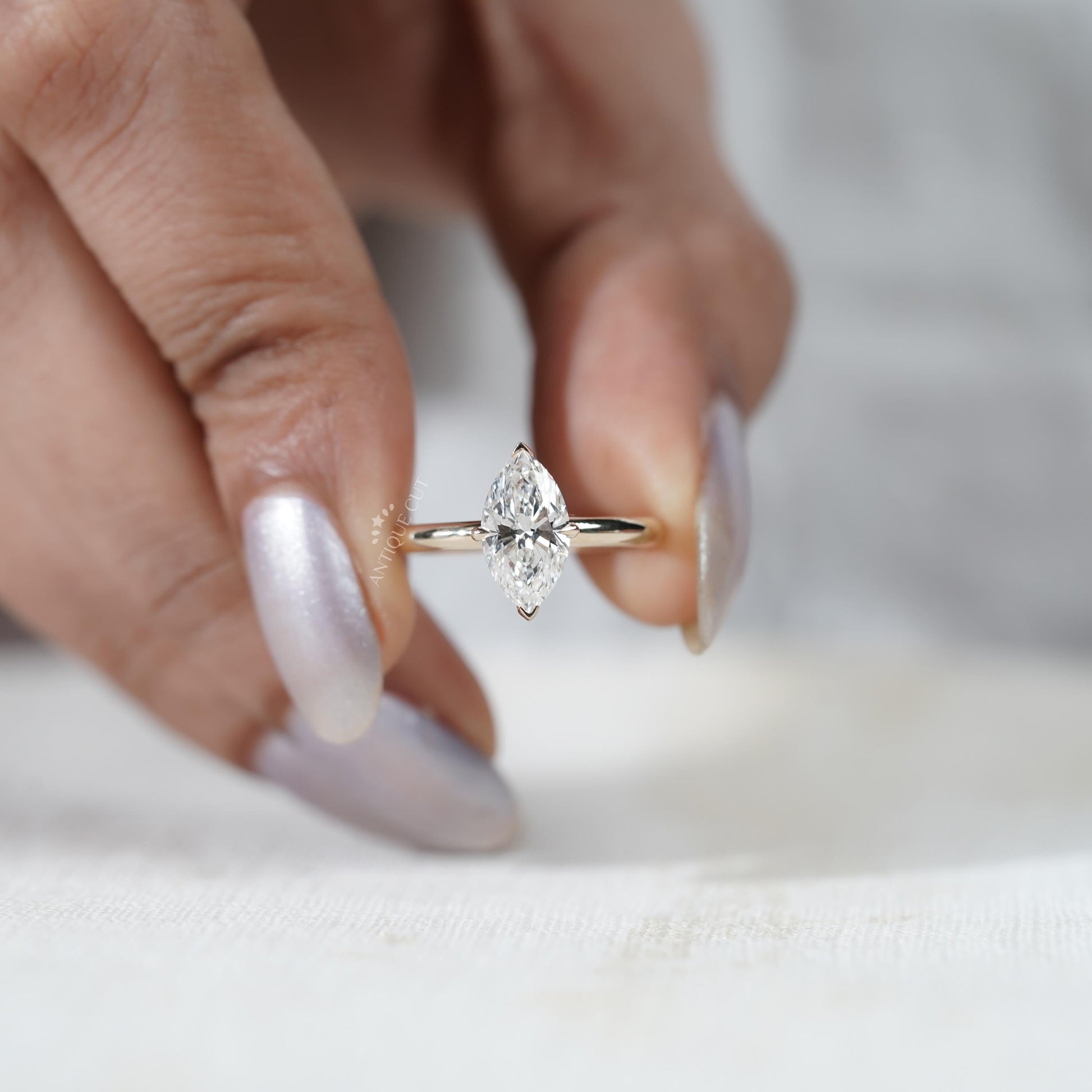 Close-up of a hand wearing a diamond ring on a white background

