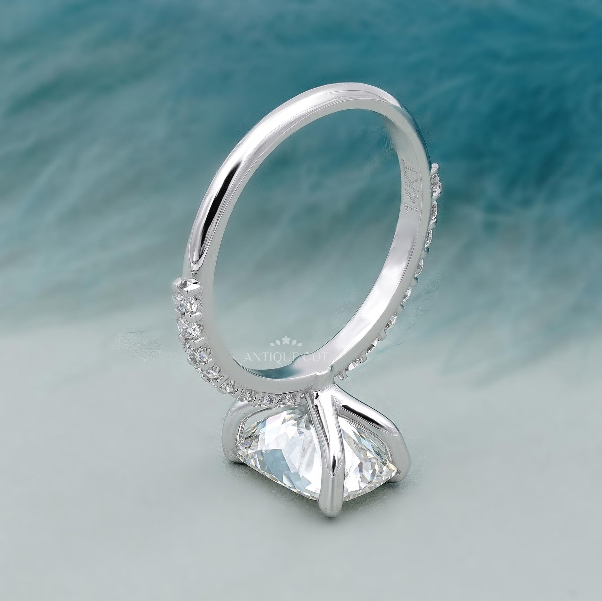 Silver ring with a large diamond on a textured blue background

