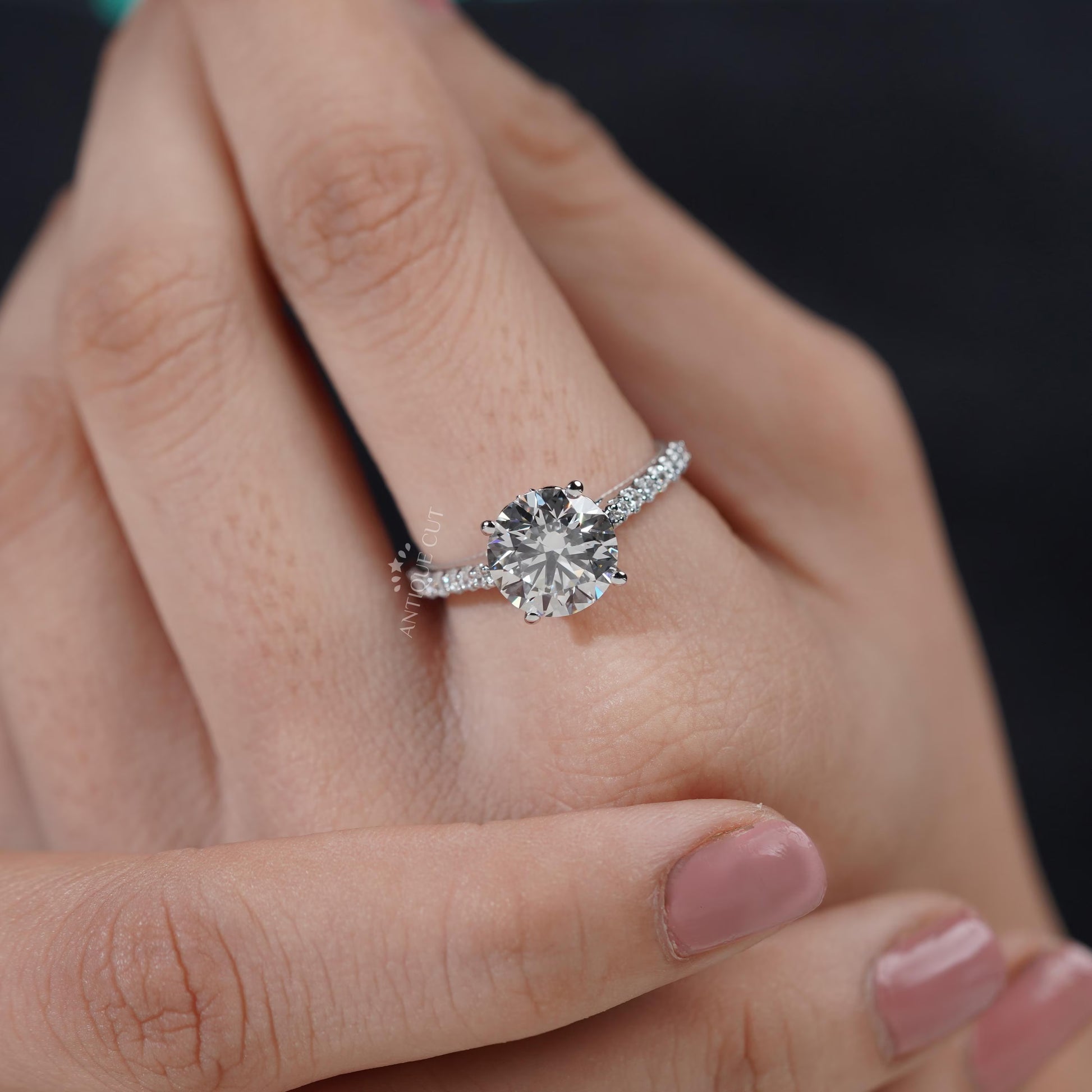 Close-up of a hand wearing a diamond ring with a blurred background